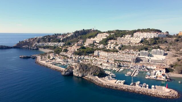 Perspective from above of costal city La Herradura situated in Granada province. View of the harbour and luxury real estate.  Drone dolly forward. Famous travel destination on Costa del Sol 