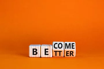 Fotobehang Become better symbol. Turned wooden cubes and changed the concept word Better to Become. Beautiful orange table orange background. Business become better concept. Copy space. © Dzmitry