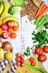 Vertical shot, assortment of healthy foods on rustic white wood. Center copy space. Zenith view.