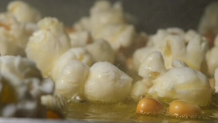 Popcorn homemade in fry pan, popcorn popping in hot cooking oil, popcorn seed exploding, Extreme close up and Slow Motion - Powered by Adobe