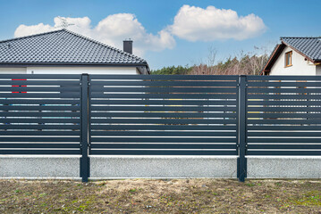 Modern anthracite panel fencing, visible spans and a fence foundation connector, view from the...