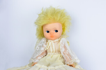 Vintage doll with yellow hair in lace dress on white background
