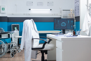 Computer with body structure on screen standing on table in empty doctors office during anatomy examination. Medical workplace having skeleton radiography. Health care services support