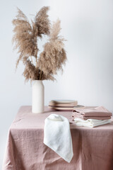 Concept of romanitic Easter table with pampas and light pink tablecloth, selective focus image