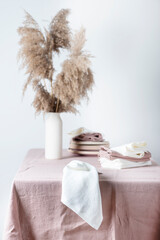 Concept of romanitic Easter table with pampas and light pink tablecloth, selective focus image