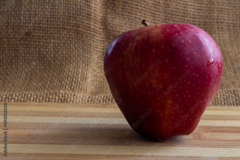 Poster red apple on burlap background with copy space.