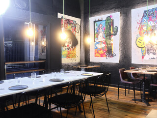 Interior of a modern restaurant decorated with paintings with graffiti