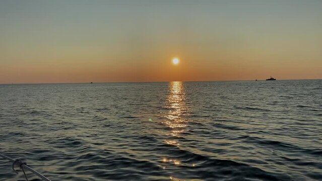 A ship standing on the roadstead against the backdrop of a beautiful sunset in the open sea.