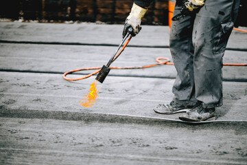 Preheating the edges of the roofing material. Repair work on the roof. Heating of the roofing...