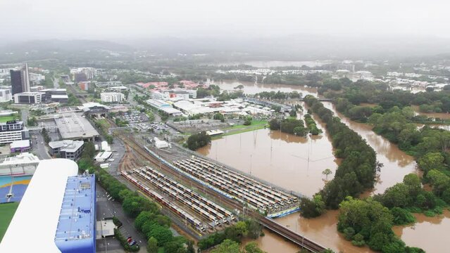 Aerial view of houses, schools and train station coming close to flooded waters during the 2022 QLD Floods Robina Gold Coast QLD Australia