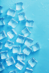 Lots of ice cubes with water drops scattered on a blue background