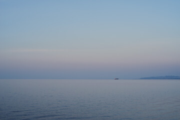 Obraz premium A boat in the sunset near the mountains