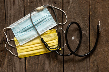 Yellow and blue medical masks such as the flag of Ukraine and a stethoscope on the table. State...