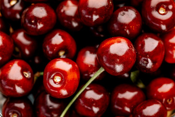 Ripe cherry with stems and leaves. A large collection of fresh red cherries. Ripe cherries background