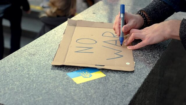 Writing of a protest sign against war in Ukraine at a rally, close up.