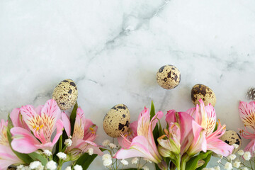 Happy easter! quail eggs with feathers and spring pink flowers on white marble background. copy space, place for text. Flat lay, top view. soft focus