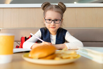 schoolchild doing homework, studing at school. girl waiting for lunch break at school. improper...