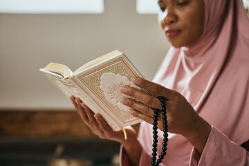 Close-up of black Muslim woman reads Koran.