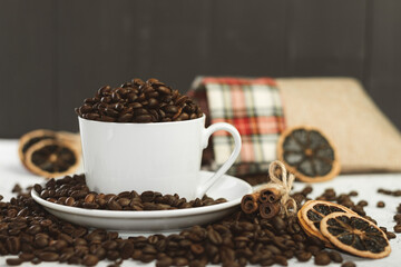 Fragrant coffee grains in a white cup on a wooden background