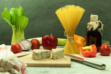 Raw pasta of various types and spices on a wooden table. View from above. Macaron on wooden table, space for text