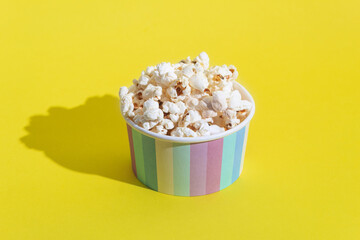 Popcorn in a cardboard box on a yellow background
