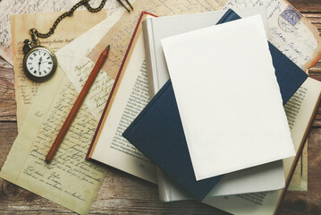 White writing sheet with copy space on top of books and postcards