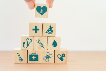 hand holding heart with elderly inside icon on wood block cube put on top of pyramid for elder...