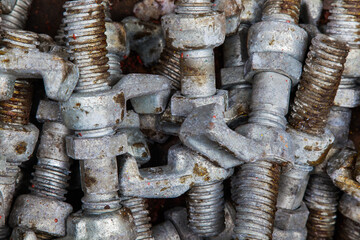 Large steel galvanized studs with nuts and clamps for containers, close-up.