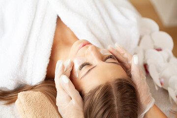 Obraz na płótnie Canvas Beautiful girl has a facial massage in a beauty clinic.