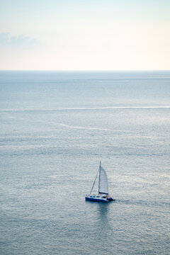 minimal Sailboat Yacht is saling on the calm sea, shoot this image from above of the mountain Phrom Thep Cape, Phuket Thailand with Tele lens.