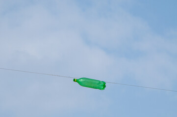 A plastic green bottle is strung through a high wire that forms a Jewish eruv or boundary...