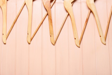 Clothes hangers on color wooden background