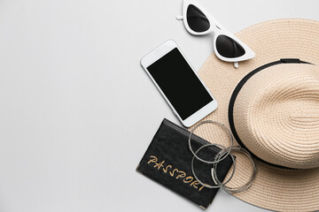 Set of beach accessories with passport and mobile phone on white background