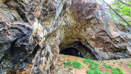 Woman at the entrance of the Drachenhoehle (Dragon Cave) in Pernegg an der Mur in Styria, Austria. Cave near mount Rothelstein in Mixnitz in the Grazer Bergland. Grotto, Europe. Hiking trail.