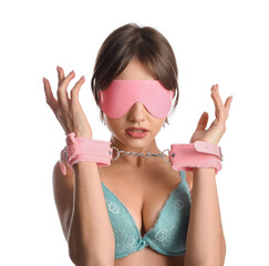 Young woman in handcuffs and with mask from sex shop on white background