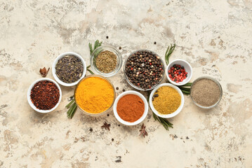 Bowls with different spices and herbs on grunge background