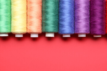 Different sewing threads on red background