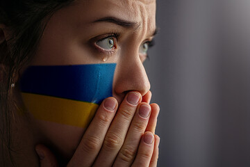 Crying sad feared depressed frightened emotional woman with Ukraine flag on face in the dark. Stop war between Russia and Ukraine. Pray and hope for peace and world. Copy space