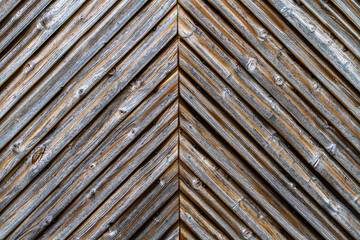 Schuppentor aus diagonal verarbeiteten Holzbrettern mit Maserung