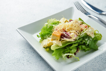 Plate of tasty vegan Caesar salad on light background, closeup