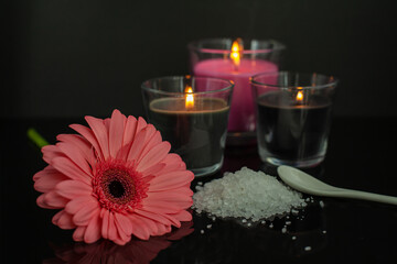 Flower, candles and salt for bathtub on black background