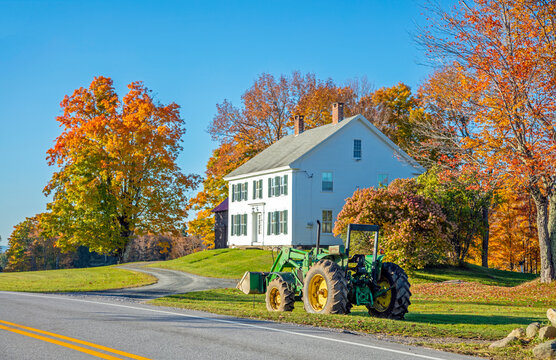 Stowe, Vermont, USA: Oct 12 2015; John Deere tractor parked on the side of a quiet road in the Vermont countryside during the fall.