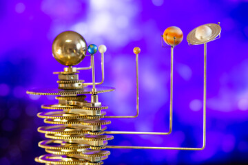 Model of the solar system made of brass close-up on a blue background