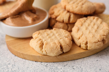 Wooden board with tasty peanut cookies on table, closeup