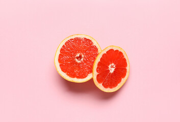 Tasty cut grapefruit on pink background