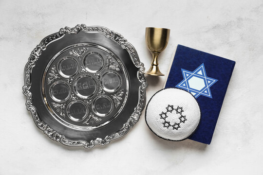 Passover Seder plate, Torah, cup and kippah on light background
