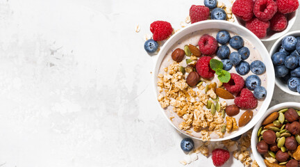 muesli with yogurt and berries for breakfast on white background, top view