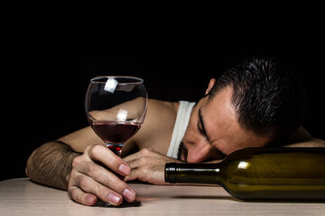 The concept of alcoholism and alcohol addiction. The man fell asleep from intoxication. Excessive wine consumption