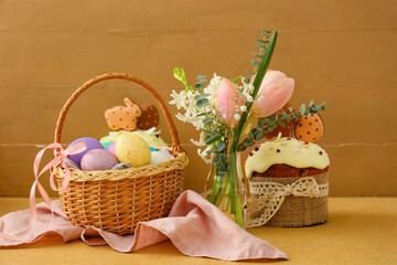 Fototapeta na wymiar Gift basket with painted Easter eggs, flowers and cake on table