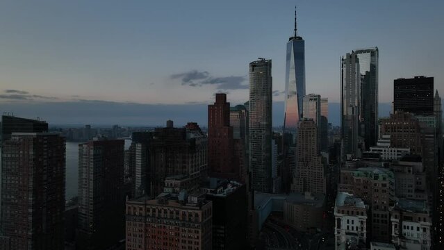 An aerial view of lower Manhattan, NY on a beautiful evening just before sunset. The drone camera, looking north towards the Freedom Tower boom down slowly.